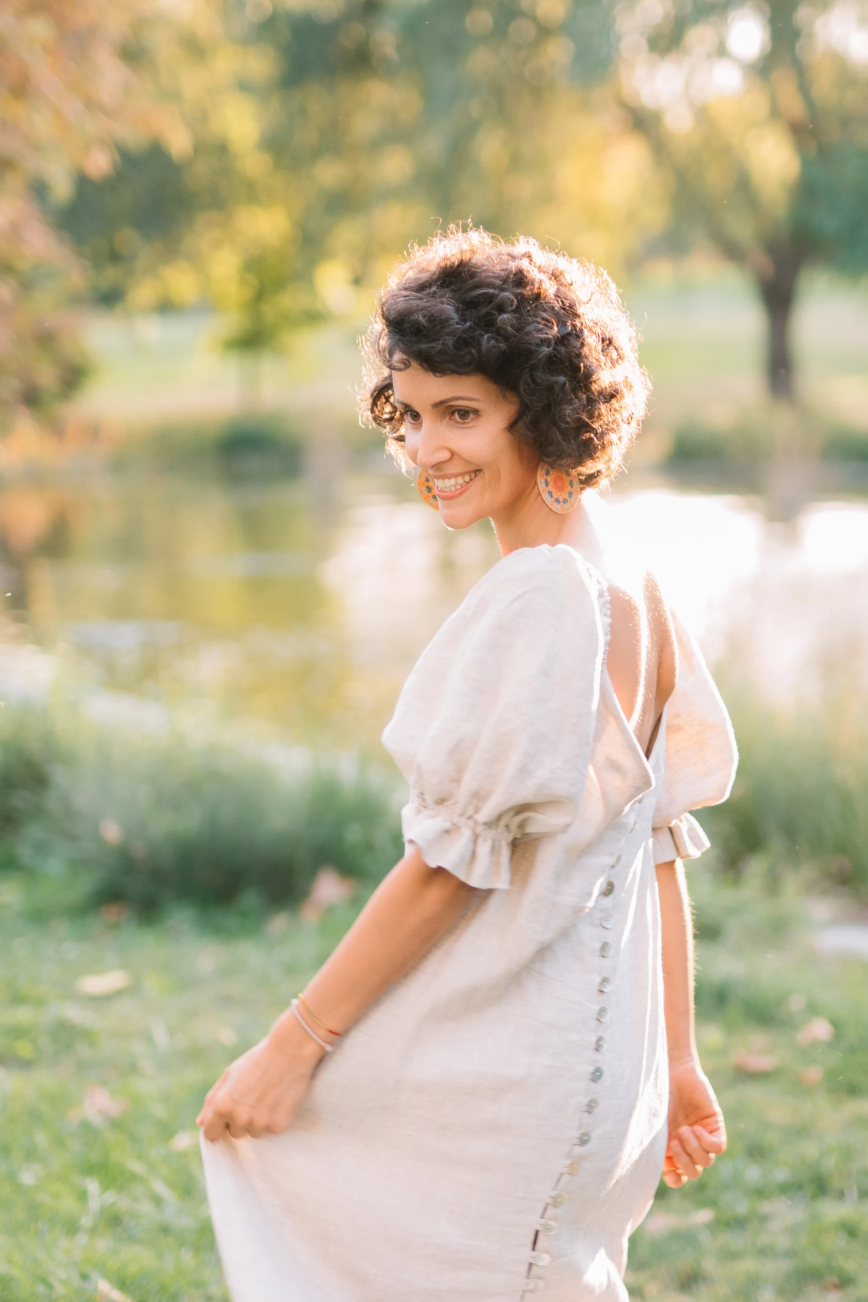 Alexandra Petrache smiling in the warm light of a garden.