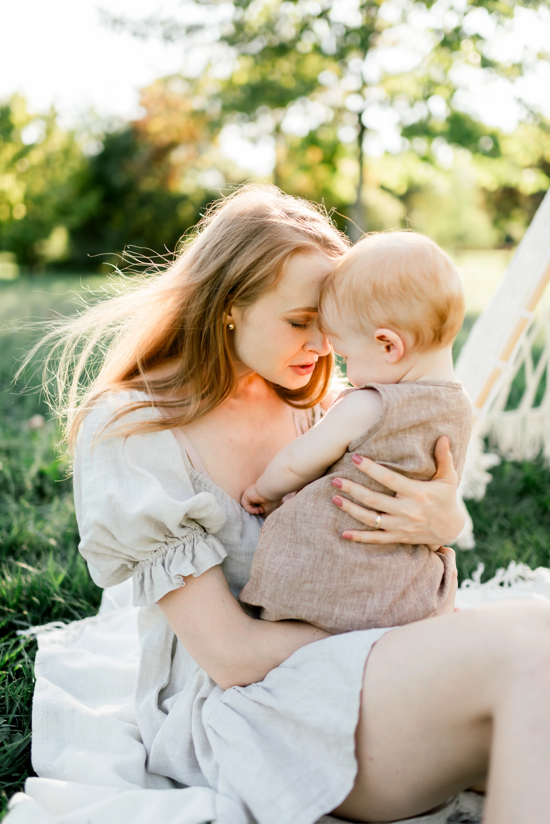 A mother holding her child close, their foreheads touching.
